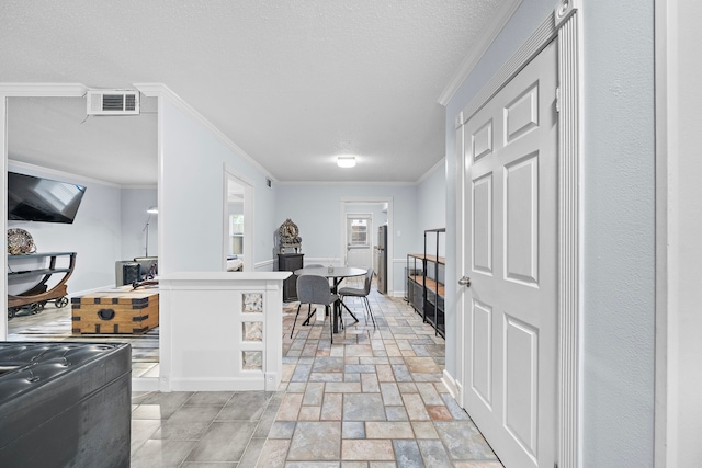 kitchen with ornamental molding and a textured ceiling