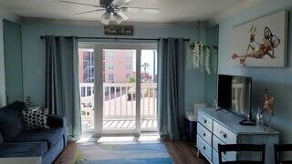 living room with wood-type flooring, ceiling fan, and crown molding