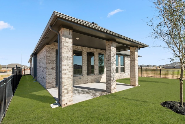 rear view of property with a lawn and a patio