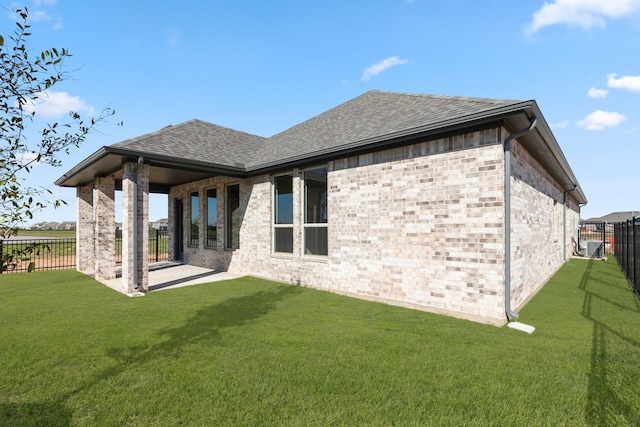 rear view of house with a yard and a patio