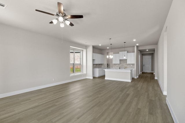 unfurnished living room featuring dark hardwood / wood-style floors and ceiling fan