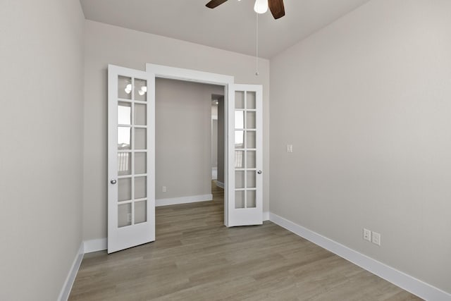 spare room featuring ceiling fan, french doors, and light wood-type flooring