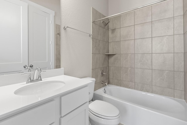 full bathroom featuring vanity, tiled shower / bath combo, and toilet