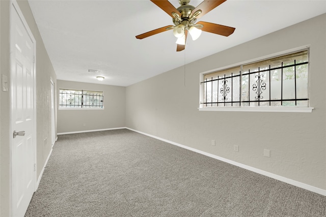 spare room with ceiling fan, carpet flooring, and a healthy amount of sunlight