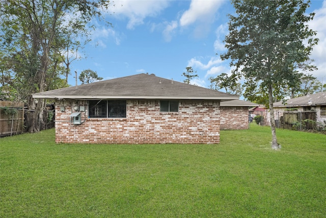 rear view of property with a yard