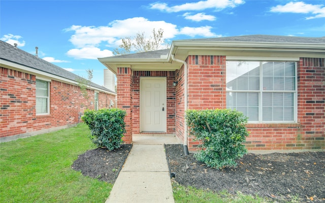 property entrance with a lawn