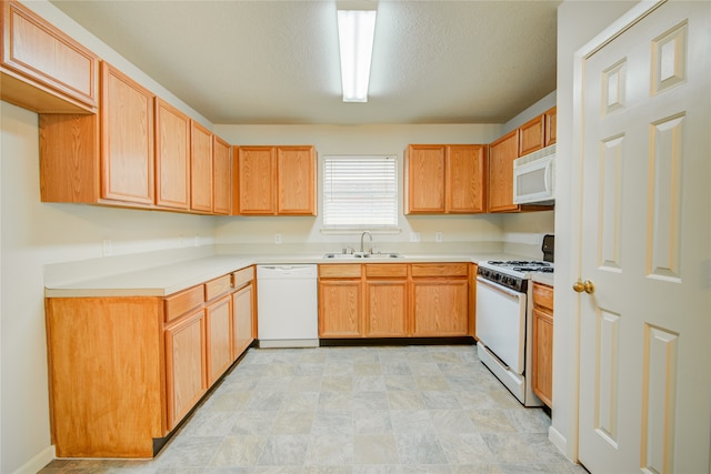 kitchen with a textured ceiling, sink, and white appliances