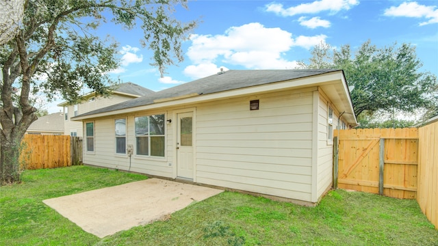 back of property with a patio area and a yard