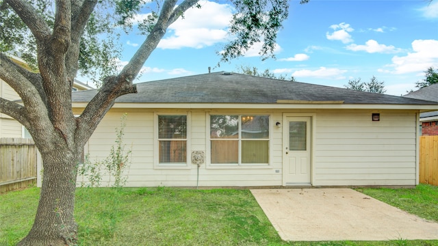 rear view of house featuring a yard and a patio area