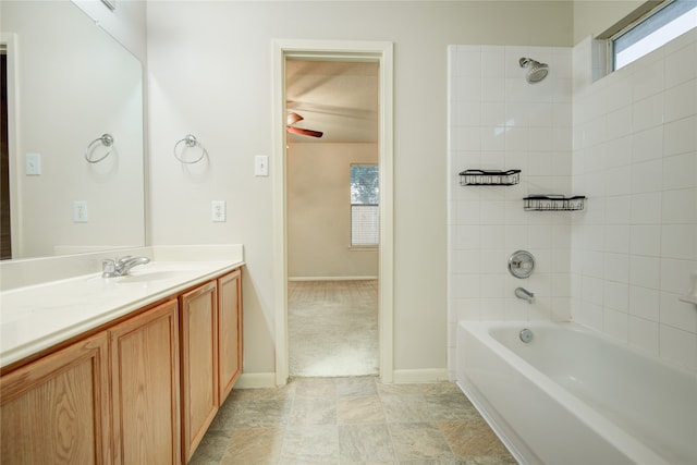 bathroom with vanity, tiled shower / bath, and ceiling fan