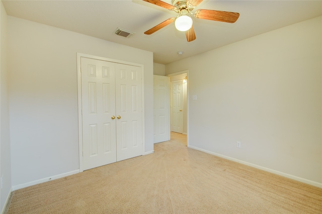 unfurnished bedroom with ceiling fan, a closet, and light colored carpet