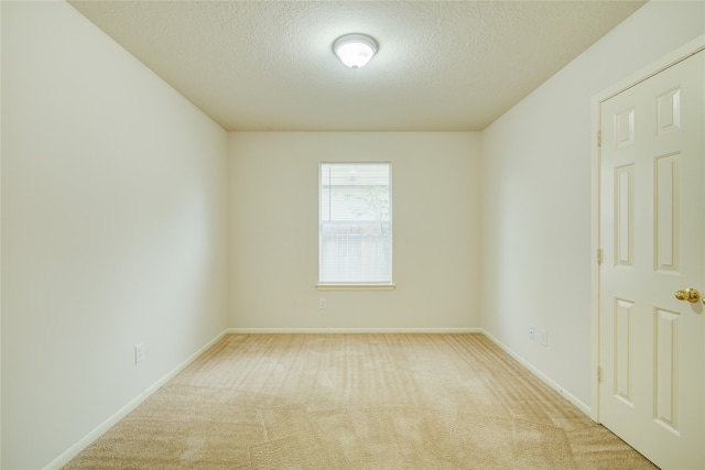 carpeted empty room featuring a textured ceiling