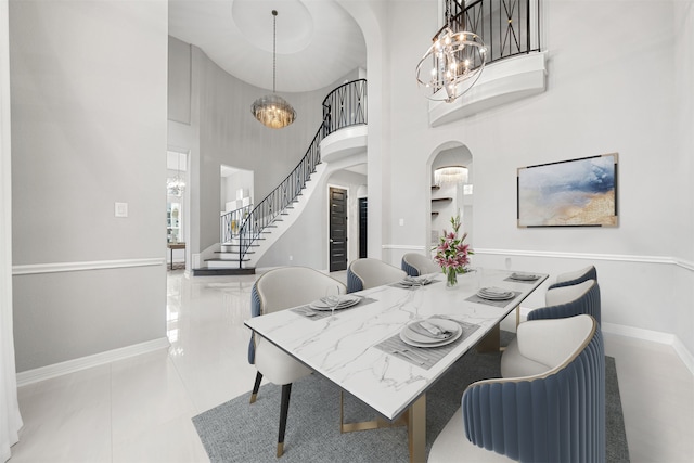 dining space featuring light tile patterned floors and a high ceiling