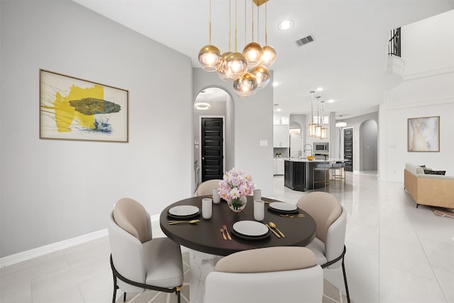 tiled dining room featuring a chandelier