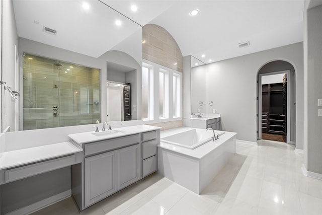 bathroom featuring tile patterned flooring, vanity, separate shower and tub, and vaulted ceiling