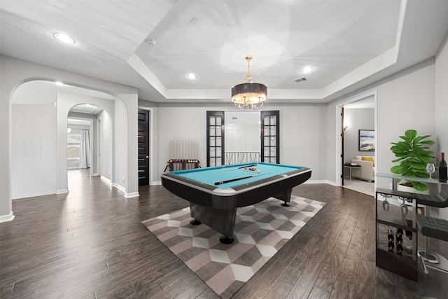 game room featuring an inviting chandelier, dark hardwood / wood-style floors, pool table, and a tray ceiling