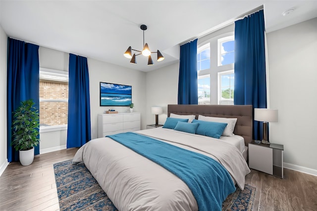 bedroom with dark wood-type flooring and a notable chandelier