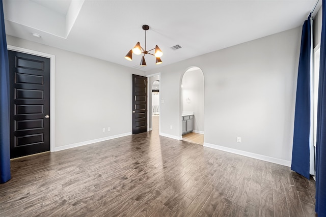 unfurnished room featuring hardwood / wood-style floors and a notable chandelier