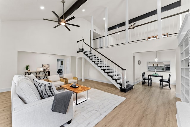 living room featuring high vaulted ceiling, light wood-type flooring, ceiling fan, and beamed ceiling