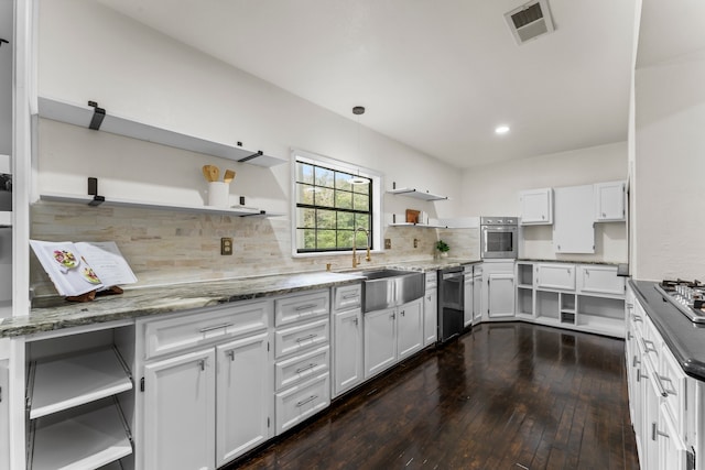 kitchen featuring white cabinets, dark wood-type flooring, pendant lighting, and appliances with stainless steel finishes