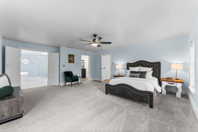 carpeted bedroom with ensuite bathroom, ceiling fan, and multiple windows