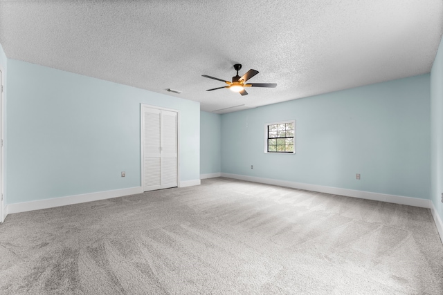 carpeted empty room with a textured ceiling and ceiling fan