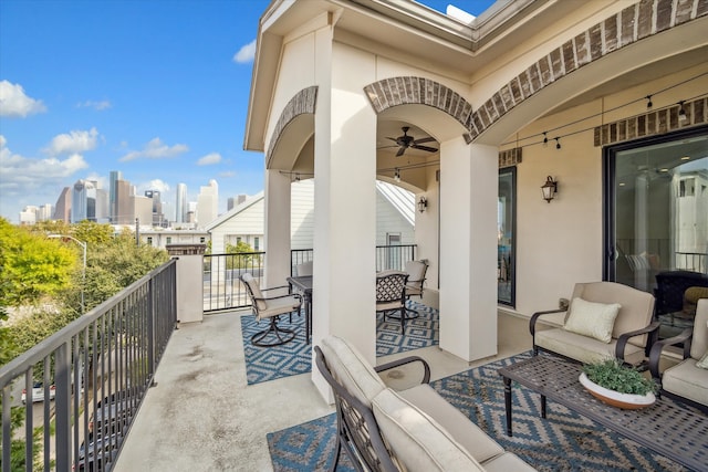 view of patio featuring an outdoor living space, ceiling fan, and a balcony