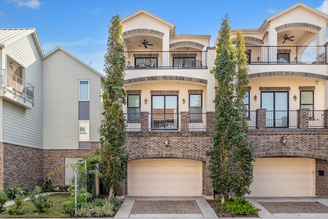 view of property with a garage, ceiling fan, and a balcony