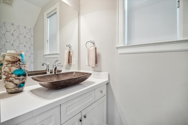 bathroom with vanity and vaulted ceiling