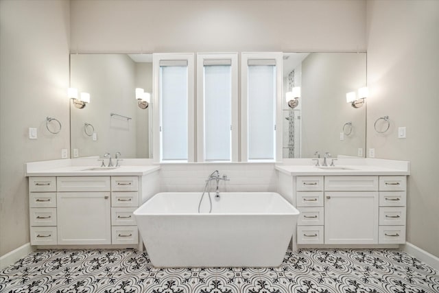 309 W Pierce St, Houston, TX 77019 - bathroom with a freestanding tub, tile patterned flooring, and two vanities