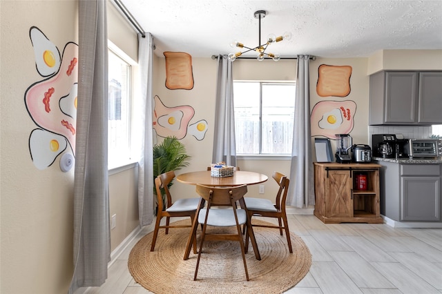 dining space featuring a textured ceiling, a healthy amount of sunlight, and a chandelier