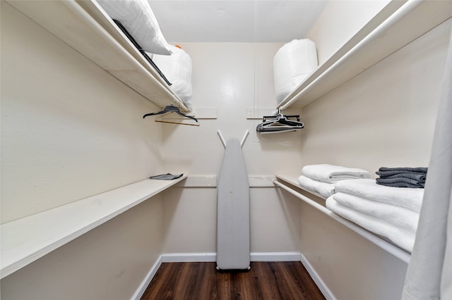 walk in closet with dark wood-type flooring