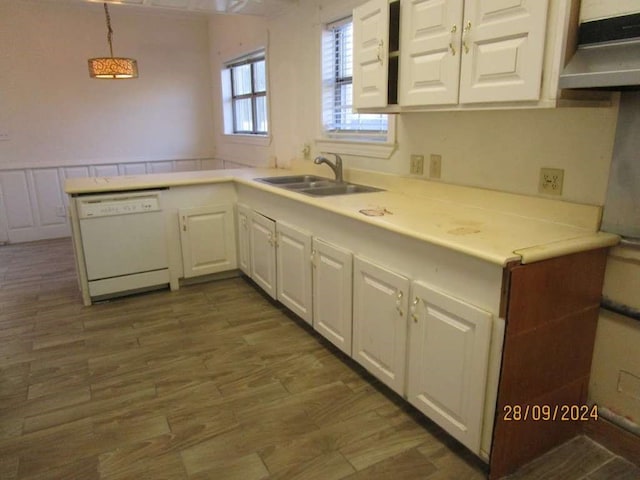 kitchen with white dishwasher, kitchen peninsula, hanging light fixtures, sink, and white cabinetry