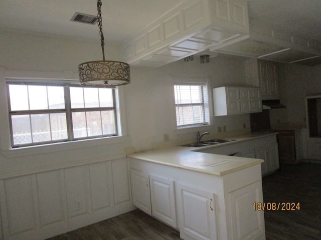 kitchen with white cabinetry, sink, kitchen peninsula, dark hardwood / wood-style floors, and ventilation hood