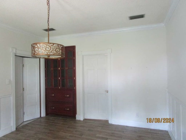 unfurnished bedroom featuring dark hardwood / wood-style floors, a textured ceiling, and ornamental molding