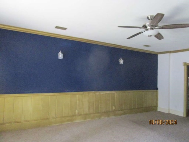 carpeted spare room featuring ceiling fan and ornamental molding