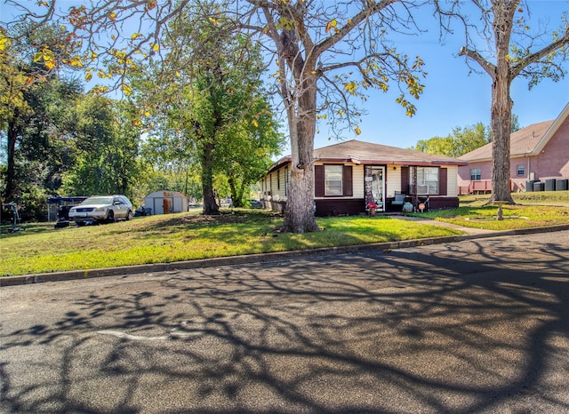 ranch-style house featuring a shed and a front lawn