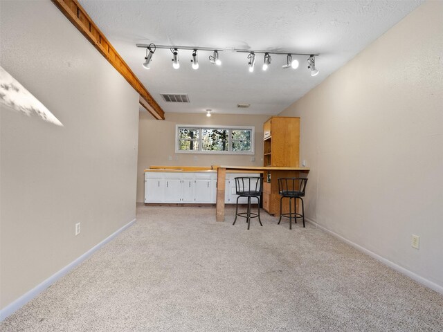 carpeted office featuring rail lighting