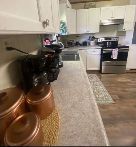 kitchen with white cabinets, dark hardwood / wood-style floors, sink, and electric range