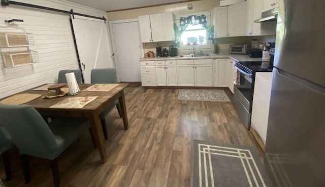 kitchen with white cabinets, stainless steel appliances, sink, and dark hardwood / wood-style flooring