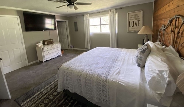 carpeted bedroom featuring wooden walls, ceiling fan, and crown molding