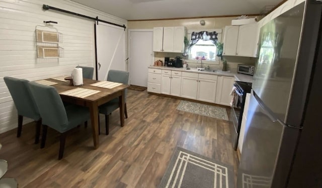 kitchen with stainless steel appliances, dark hardwood / wood-style flooring, white cabinets, a barn door, and sink