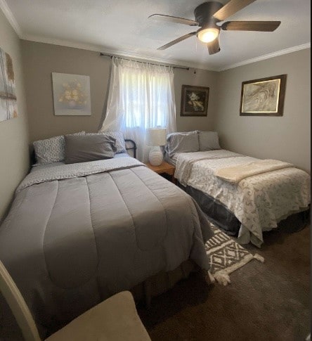 carpeted bedroom featuring ornamental molding and ceiling fan