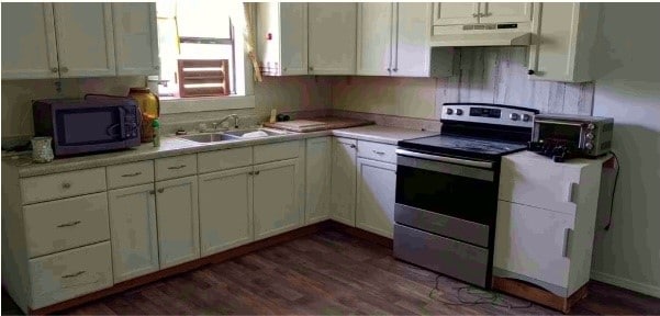 kitchen featuring dark hardwood / wood-style flooring, white cabinetry, sink, and stainless steel appliances