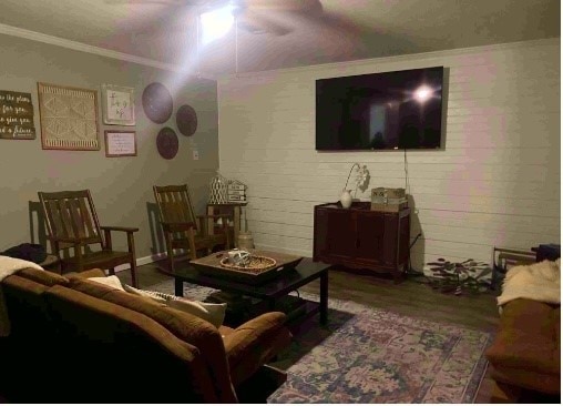 living room featuring hardwood / wood-style flooring, ceiling fan, and ornamental molding