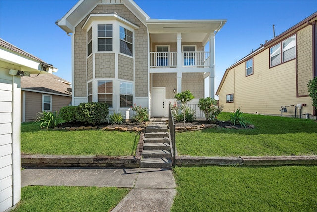 view of front of house with a front lawn and a balcony