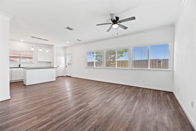 unfurnished living room with ornamental molding, dark wood-type flooring, and ceiling fan