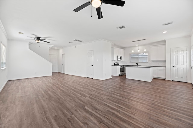 unfurnished living room featuring dark hardwood / wood-style floors, crown molding, and ceiling fan