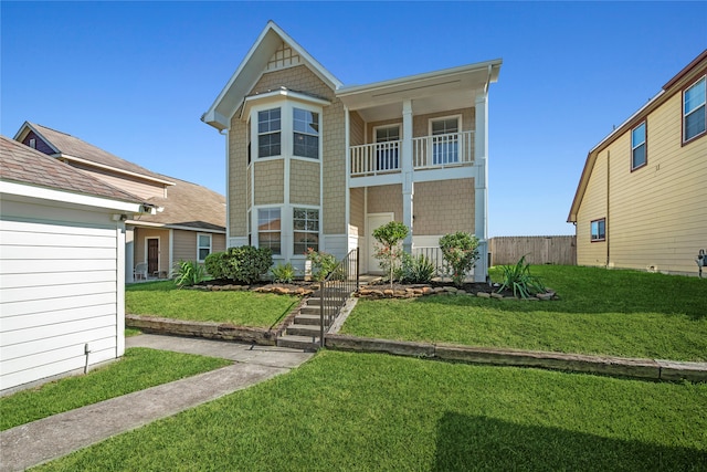 view of front of home featuring a front yard and a balcony