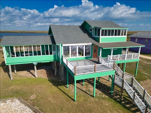 back of house with a sunroom and a yard